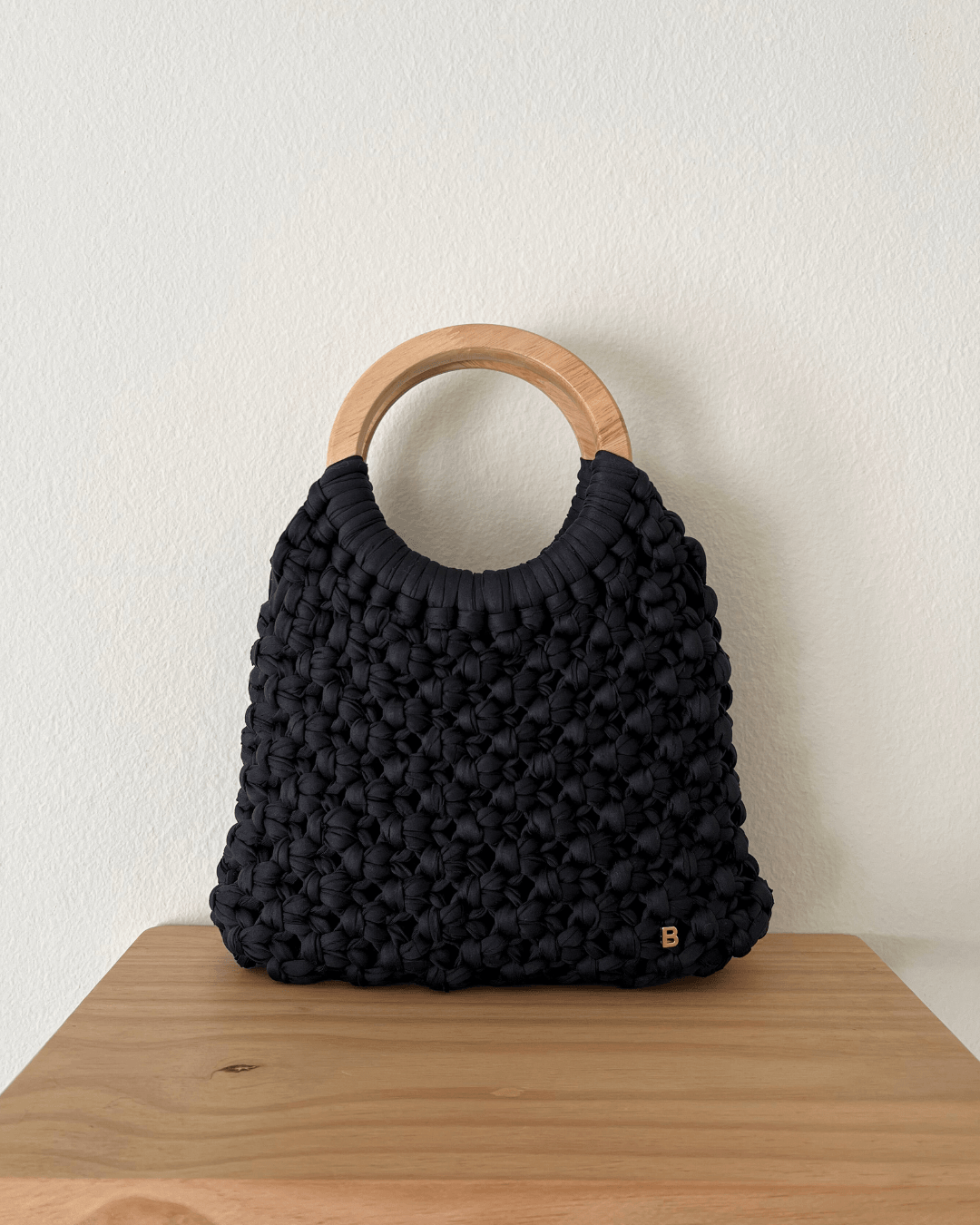 Gala Bag en negro, hecho a mano con nudos macramé sobre asas de madera.