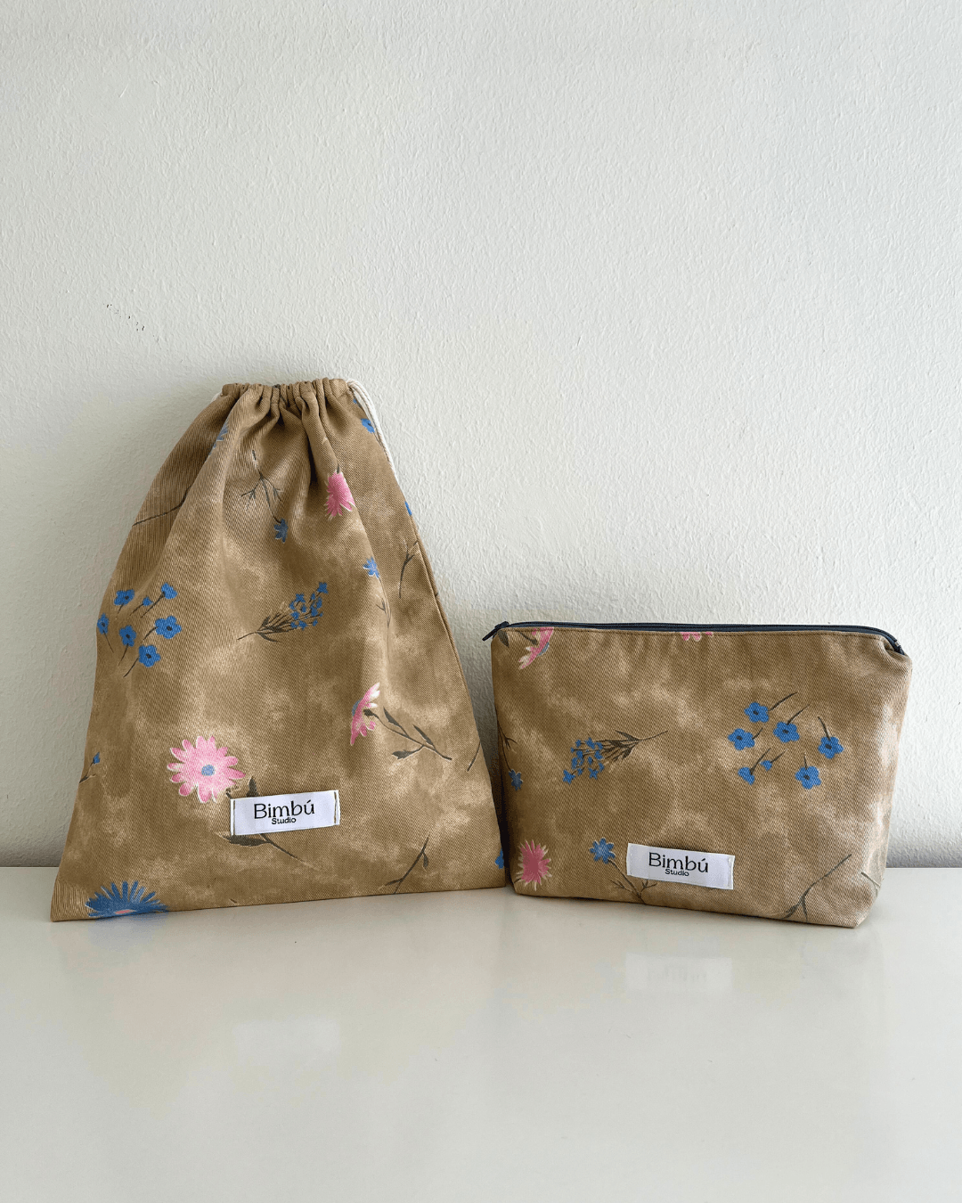Neceser y bolsa de tela a conjunto, pack personalizado con tela de diseño de flores rosas y azules sobre fondo beige.