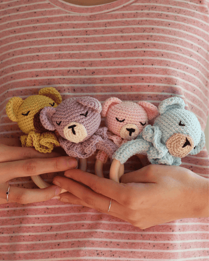 Sonajeros Mel de osito de color amarillo, lila, rosa y azul. Hechos a mano a crochet con hilo de algodón, vista de cerca.